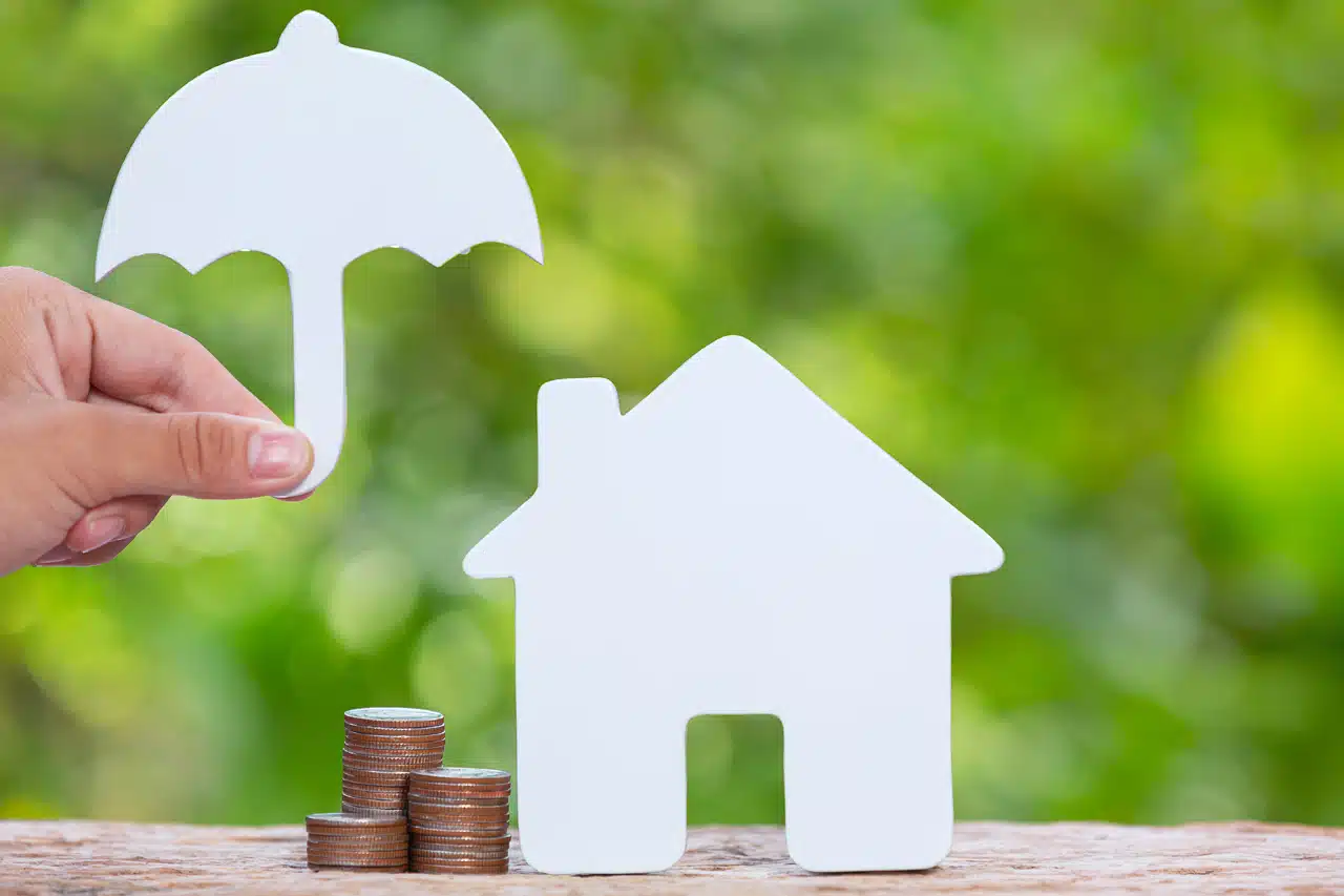 photo illustant l'assurance vie avec un montage en papier d'une maison et d'un parapluie