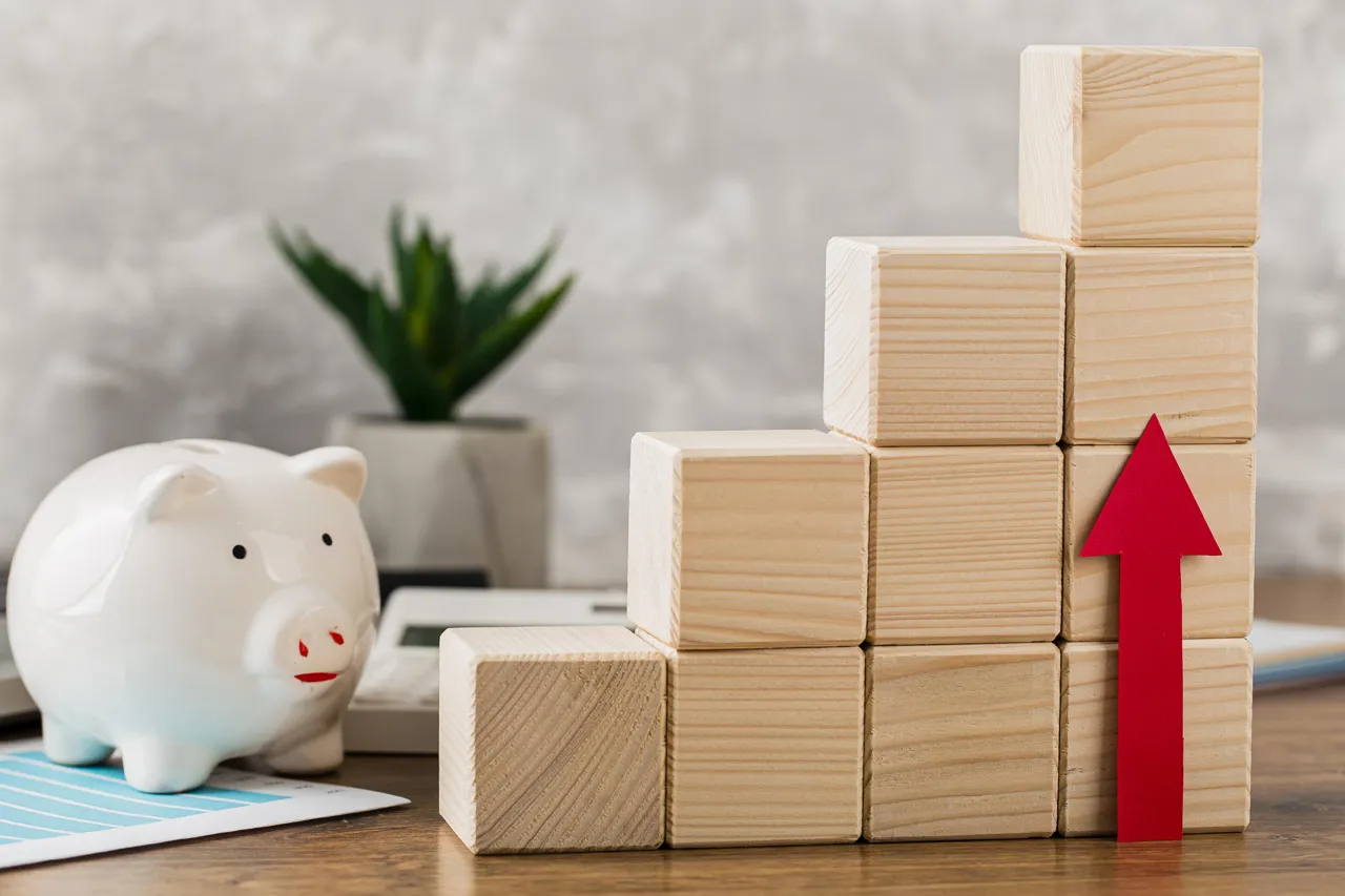 Un cochon en porcelaine et des cubes en bois illustrant la progression des placements